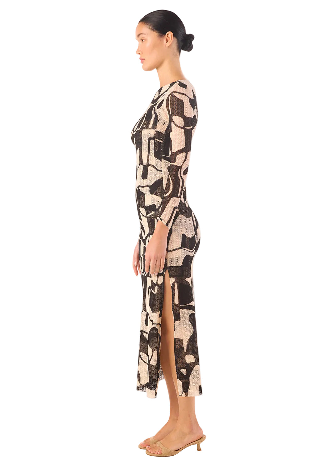 Woman wearing a patterned dress with a side slit on a white background