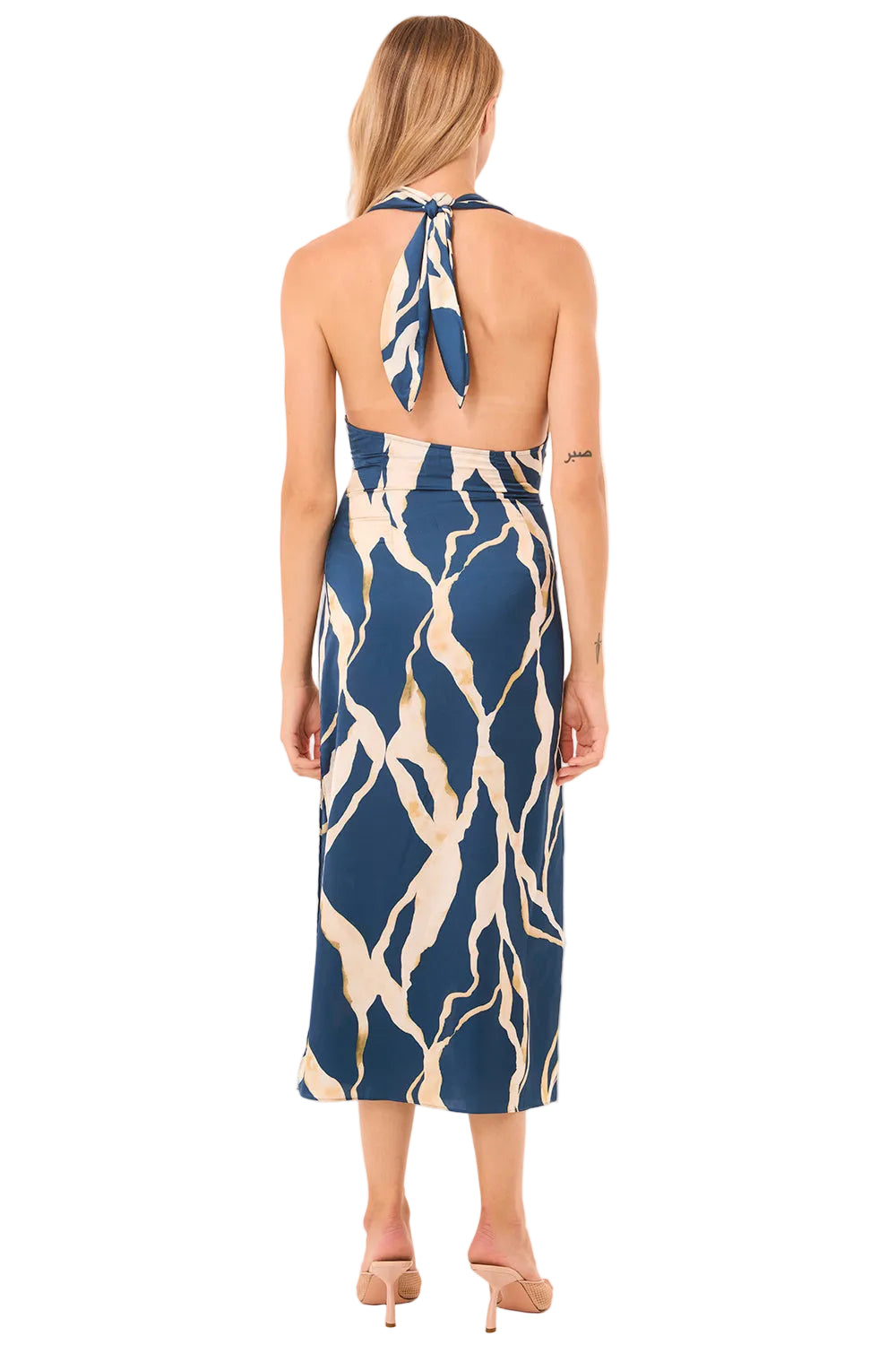 Woman wearing a blue and beige patterned dress on a beige background