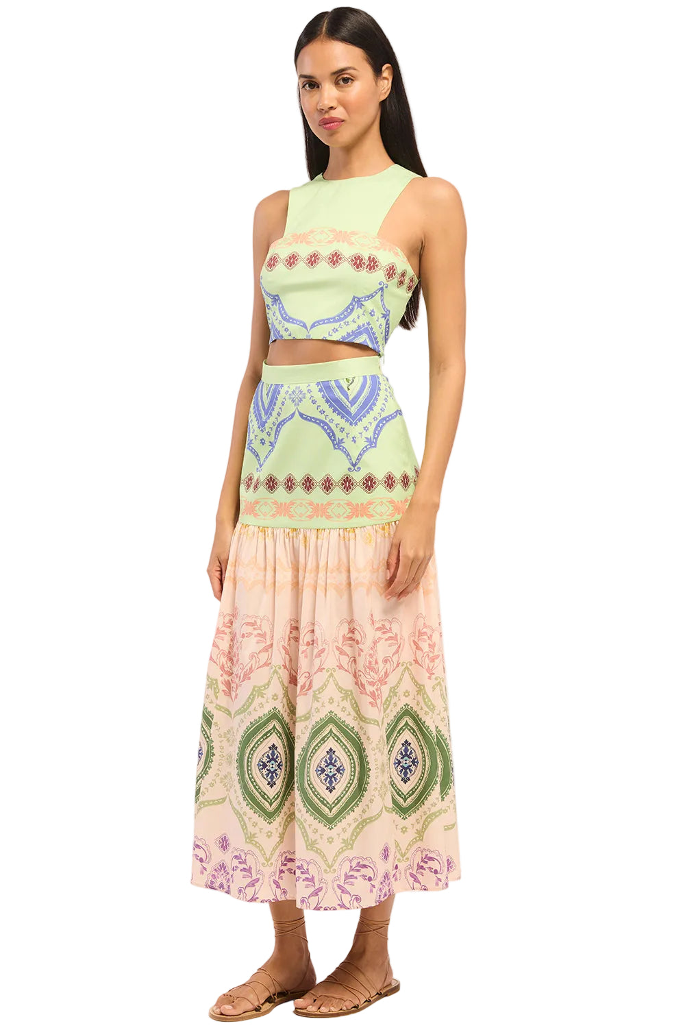 Woman wearing a patterned top and skirt on a white background