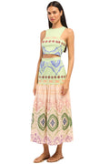 Woman wearing a patterned top and skirt on a white background