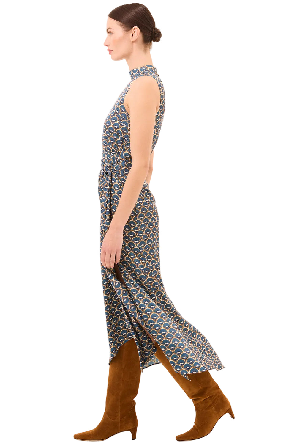 Woman wearing a patterned dress and brown boots on a white background