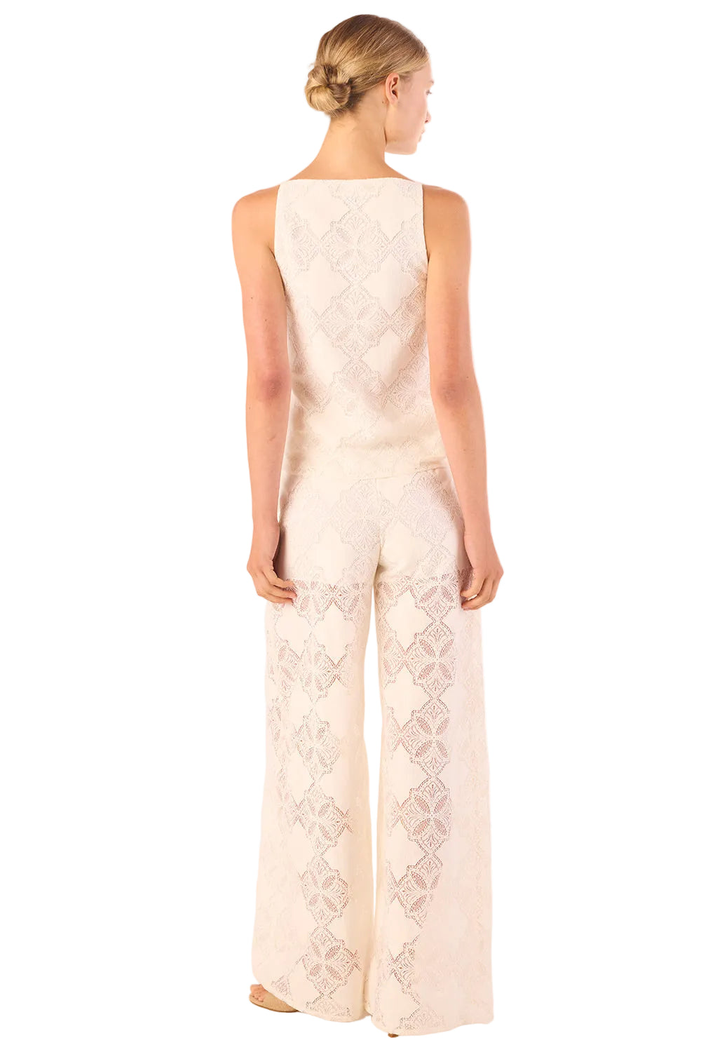 Woman wearing a white lace jumpsuit on a white background