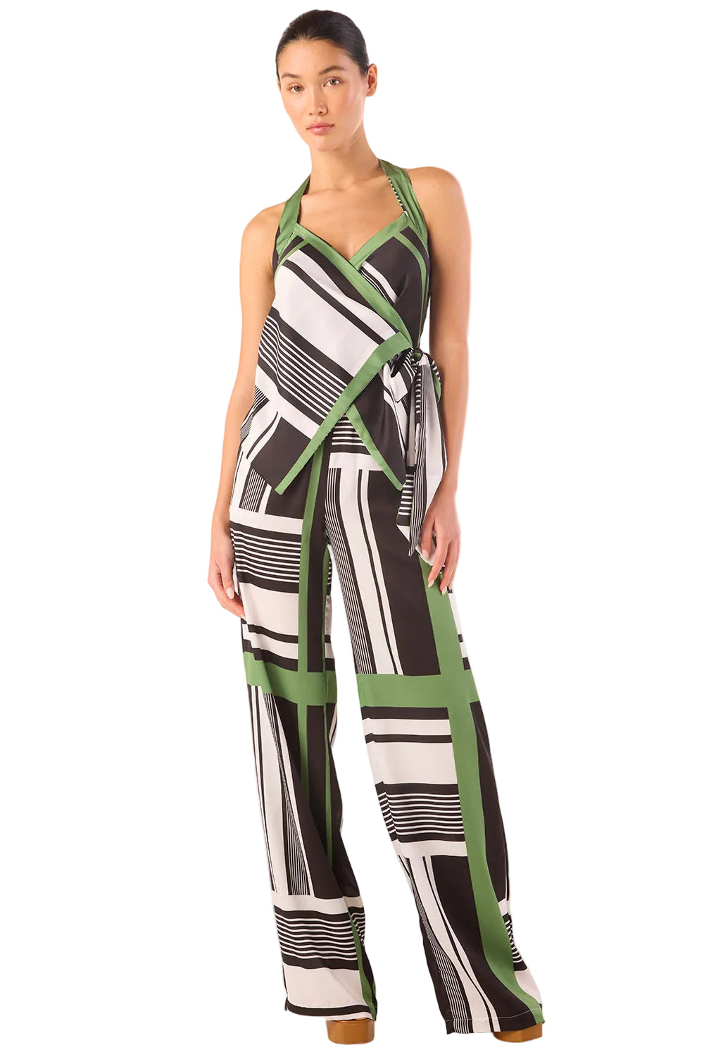 Woman wearing a black, white, and green patterned jumpsuit on a white background