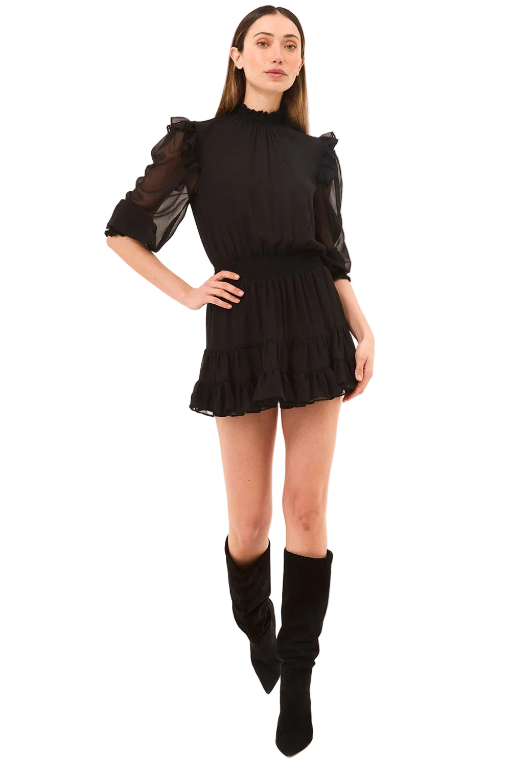 Woman wearing a black outfit with sheer sleeves on a beige background