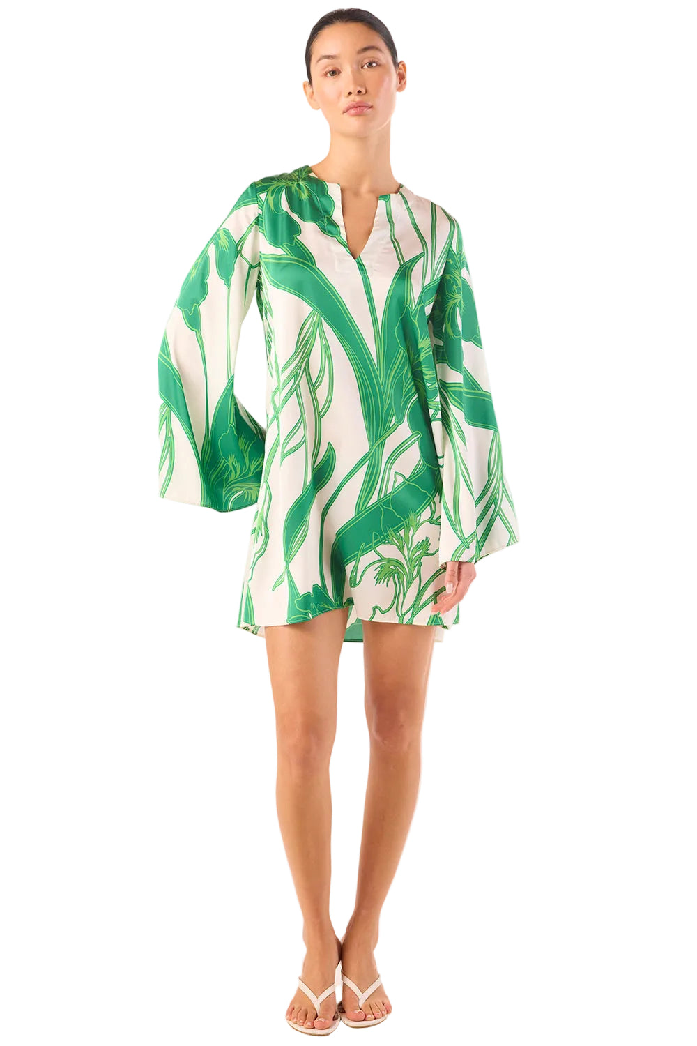 Woman wearing a green and white leaf-patterned dress on a white background