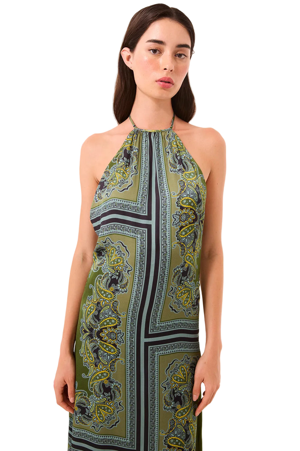 Woman wearing a green patterned halter neck dress on a beige background
