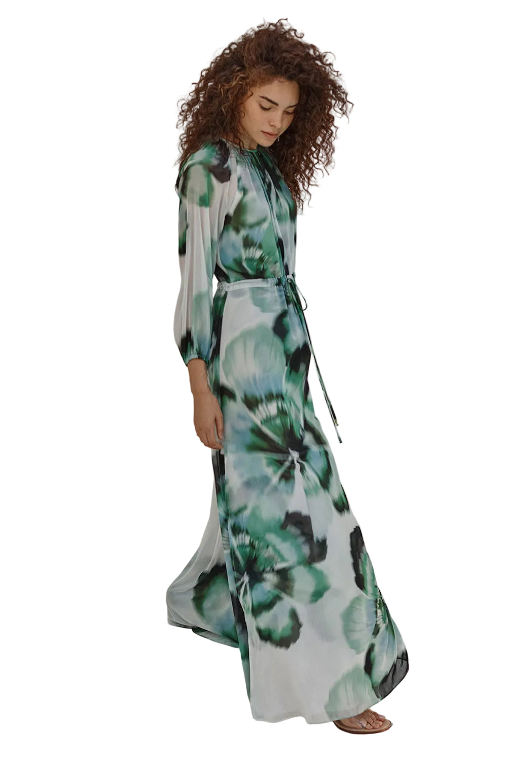 Woman wearing a floral dress standing in a minimalistic setting