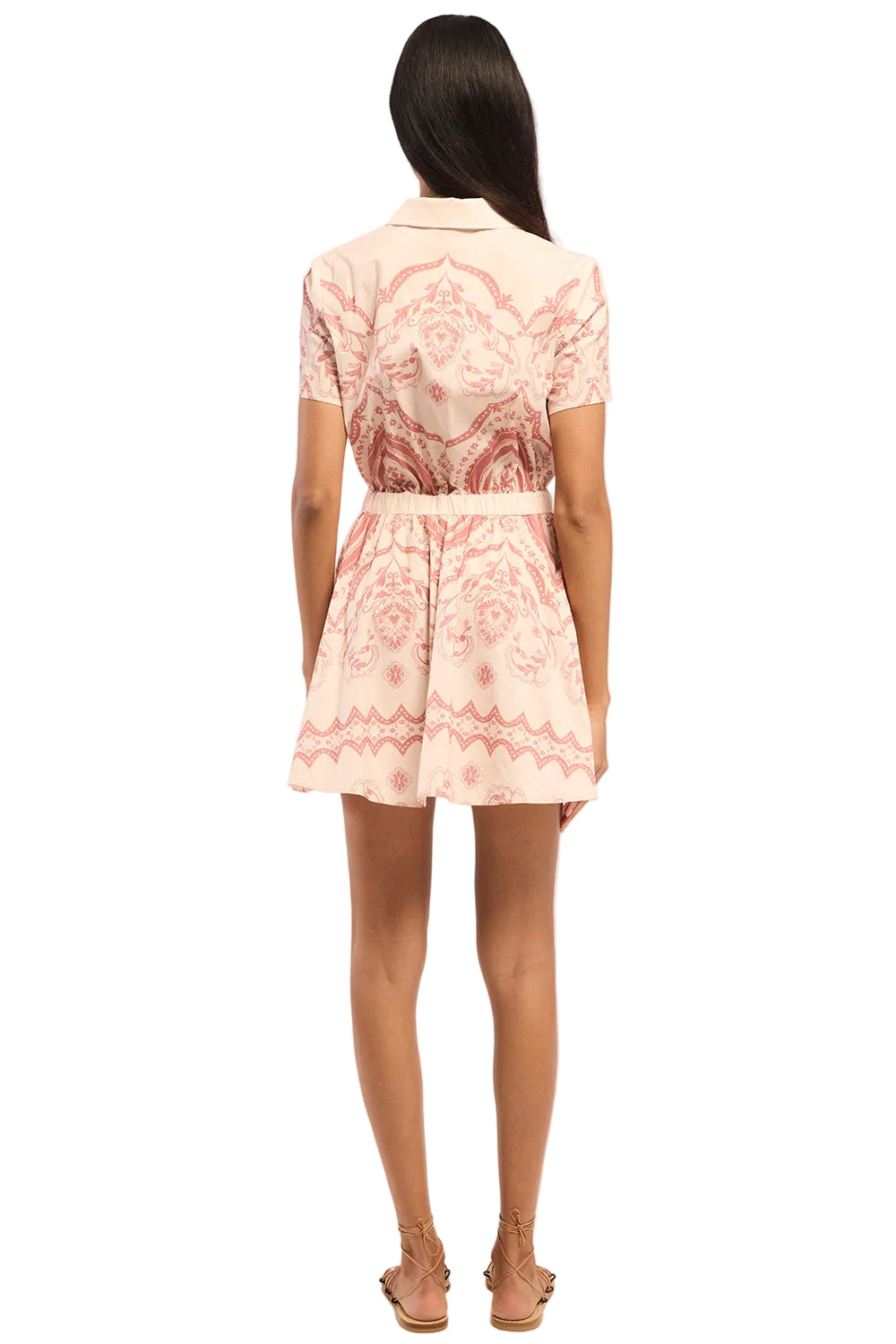 Woman wearing a pink patterned dress on a white background
