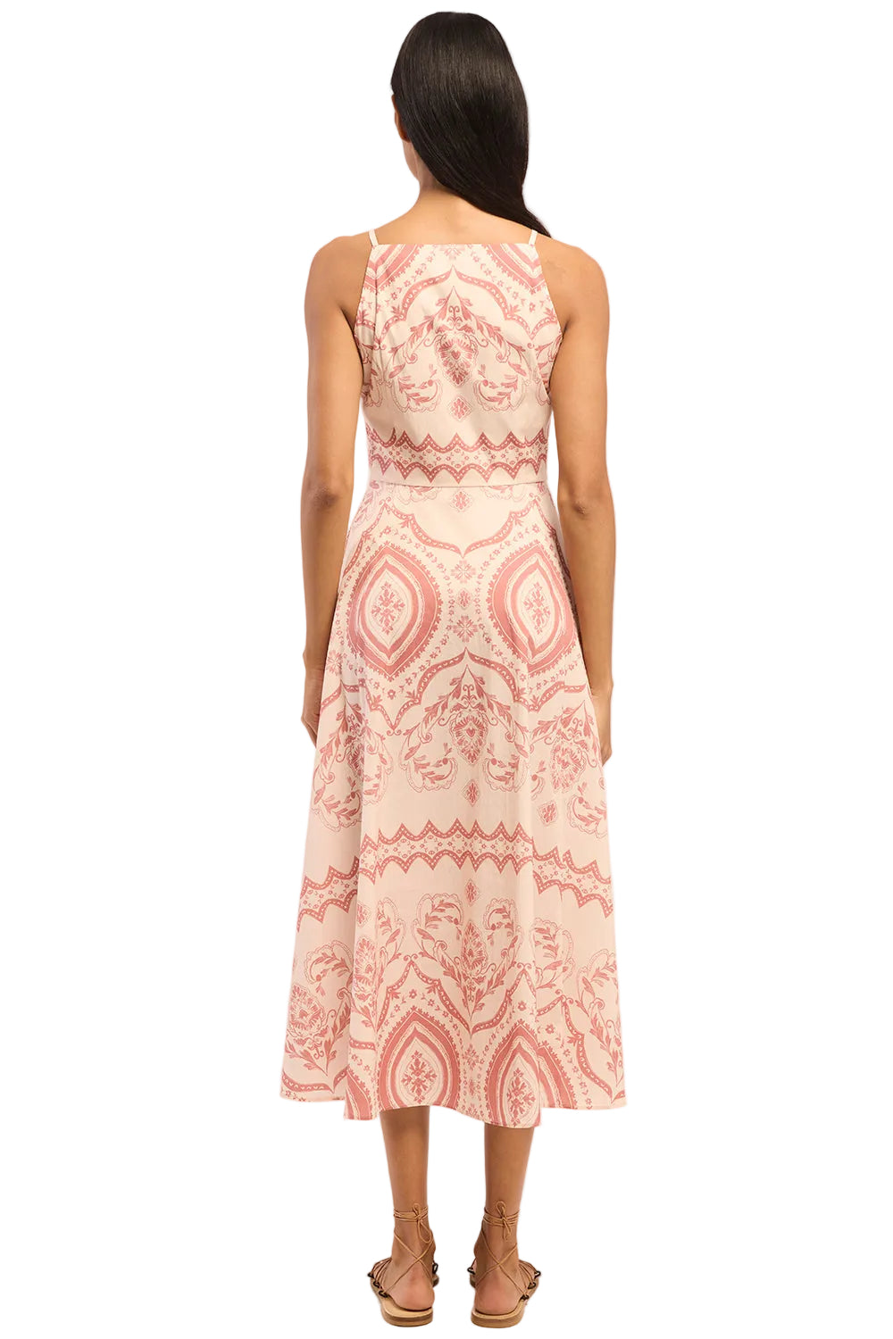 Woman wearing a pink and white patterned dress on a white background